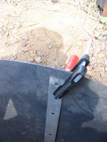 Preparing to drill pilot holes to attach metal strips to bamboo barrier
