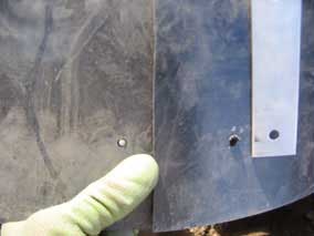 Feeding bolt through pilot holes near bottom of barrier