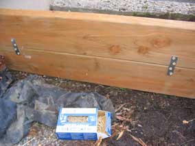 Planting bed end wall secured with mending plates and screws