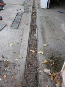 Trench drain full of silt and debris