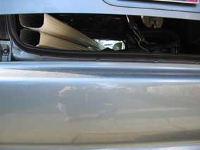 Downspout sections squeezed into car, trunk held down with rubber strap