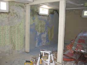 Scraping wallpaper off the concrete walls