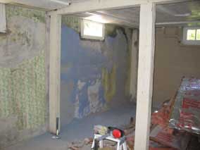 Scraping wallpaper off the concrete walls