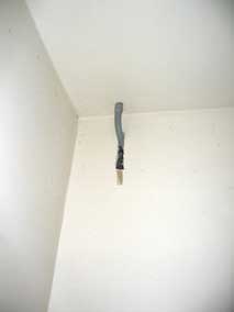 PVC conduit elbow routing electrical wire from wall to ceiling into attic
