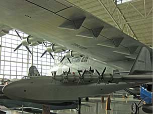 Scale model of the <em>Spruce Goose</em> under the wing of the actual plane