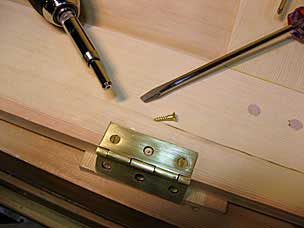 Setting screws in hinge for tool chest lid